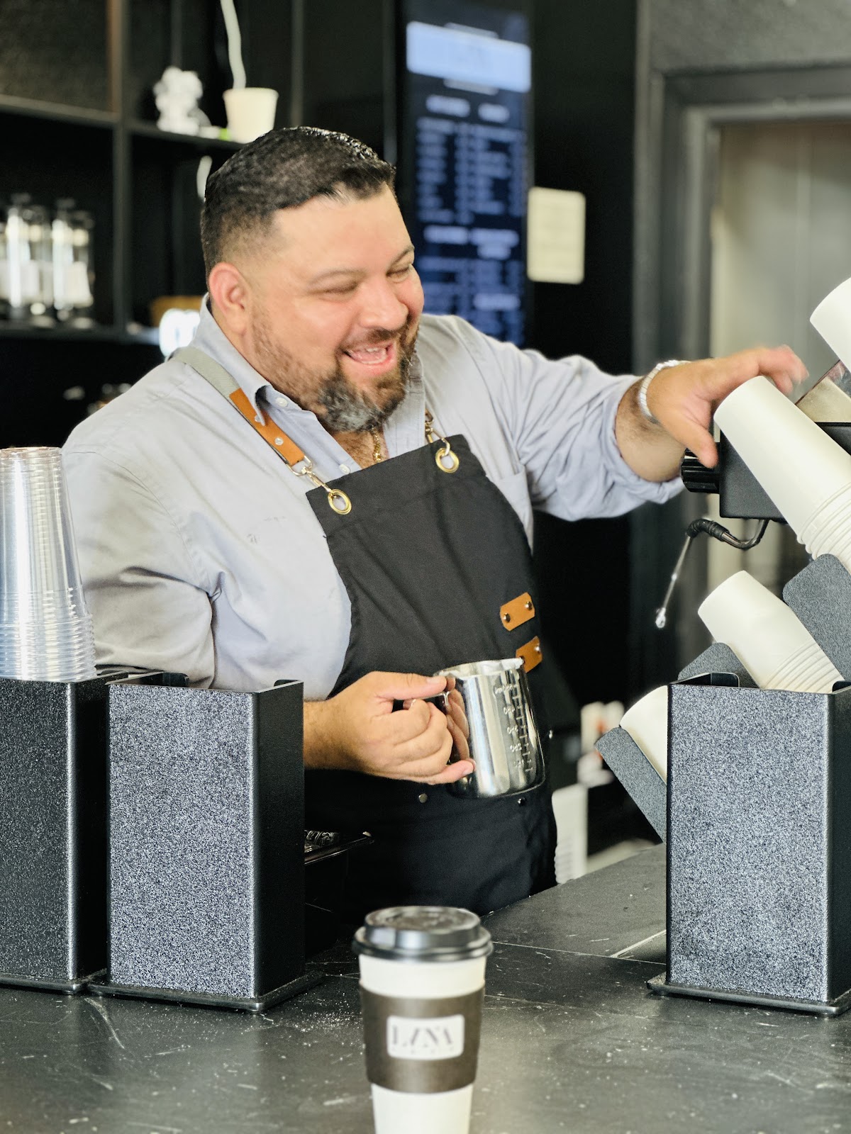 The owner of LVNA Cafe at the espresso machine